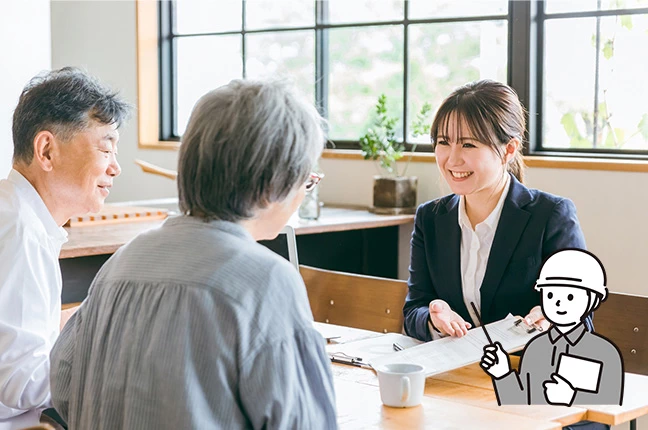 相談窓口のアドバイザーが、年配の女性に対して資料を使いながら優しく丁寧に解説している様子